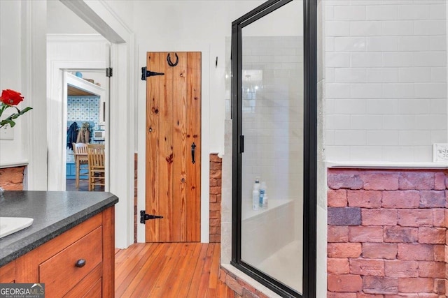 bathroom with a shower stall, wood finished floors, and vanity