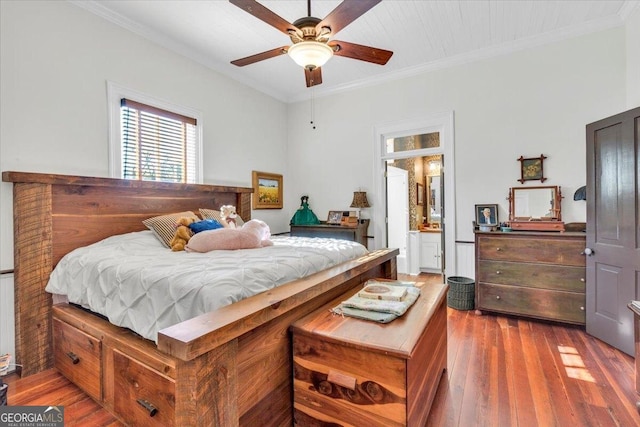 bedroom with ornamental molding and wood finished floors