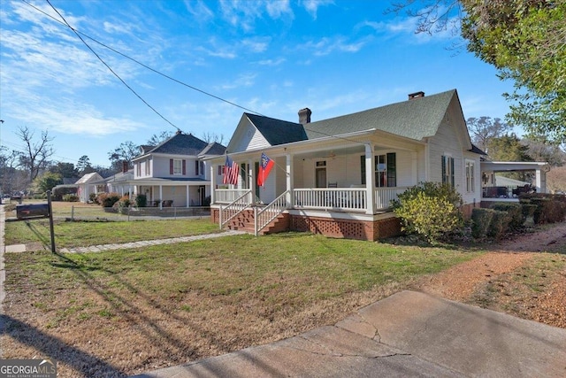 view of front of house with covered porch, fence, a chimney, and a front lawn