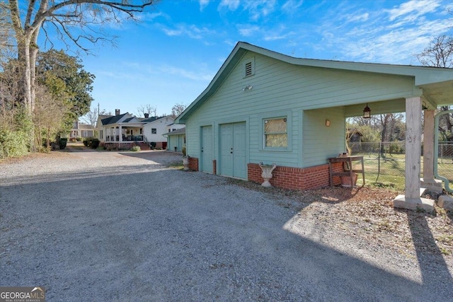 view of home's exterior featuring a garage, driveway, and fence