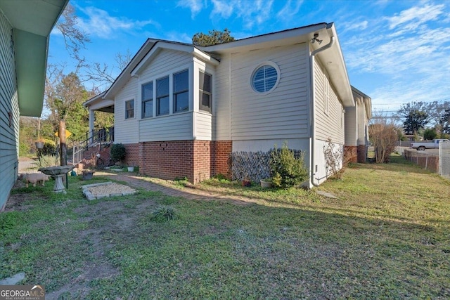 view of side of property with a yard and brick siding