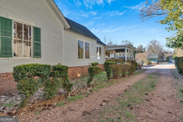 view of home's exterior with roof with shingles and crawl space