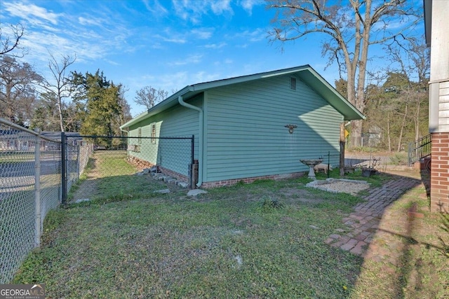 view of property exterior with fence and a yard