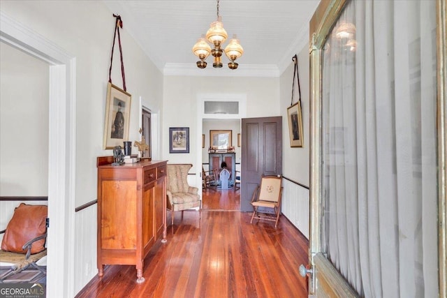 corridor featuring crown molding, a chandelier, and dark wood-style flooring