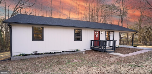 view of front facade with roof with shingles and crawl space