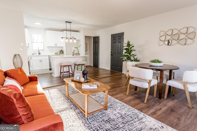 living room with wood finished floors and a notable chandelier