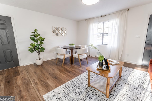 living area featuring baseboards and wood finished floors