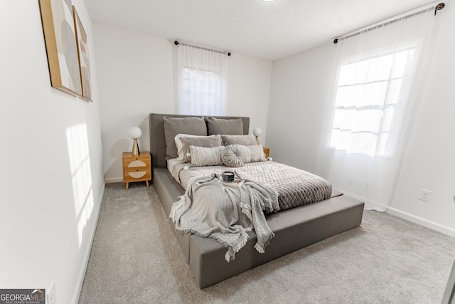 bedroom featuring baseboards, multiple windows, and carpet flooring