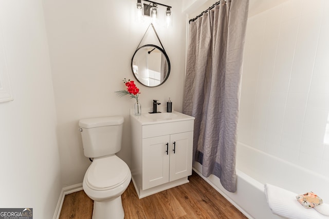 full bathroom with toilet, shower / tub combo, wood finished floors, vanity, and baseboards