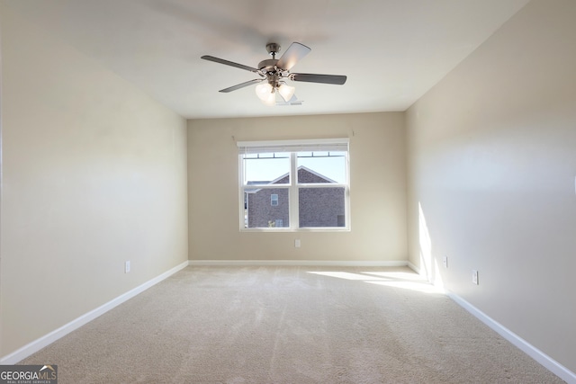 carpeted empty room with baseboards and a ceiling fan