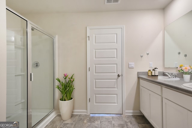 bathroom with a stall shower, baseboards, visible vents, and vanity