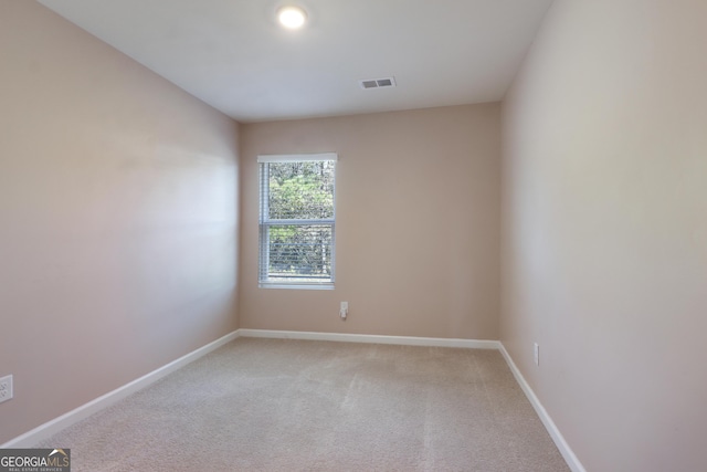 spare room with light carpet, baseboards, and visible vents