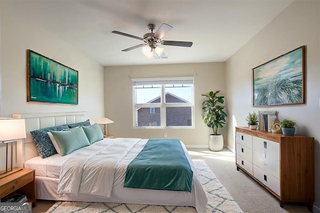 carpeted bedroom with ceiling fan and baseboards