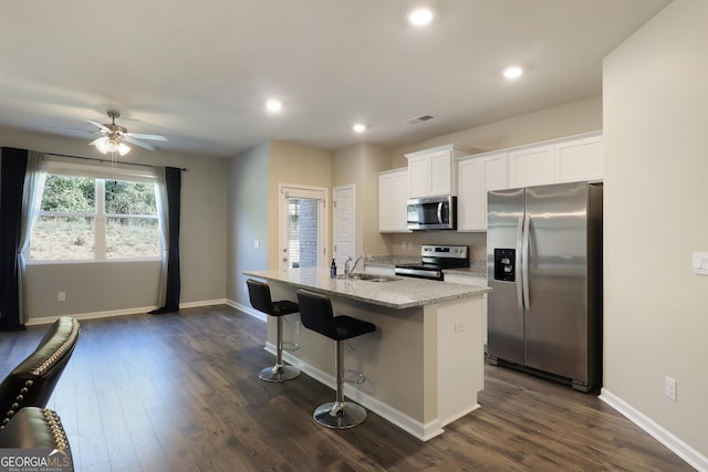 kitchen with a kitchen island with sink, a sink, visible vents, white cabinetry, and appliances with stainless steel finishes