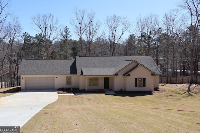 view of front facade with driveway, a front lawn, an attached garage, and fence