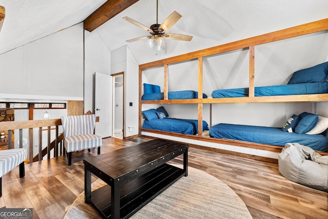 bedroom featuring vaulted ceiling with beams, a textured ceiling, and wood finished floors