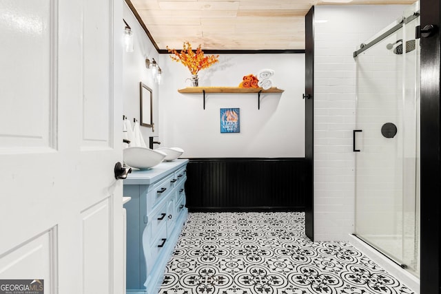 full bath with a wainscoted wall, vanity, and a stall shower