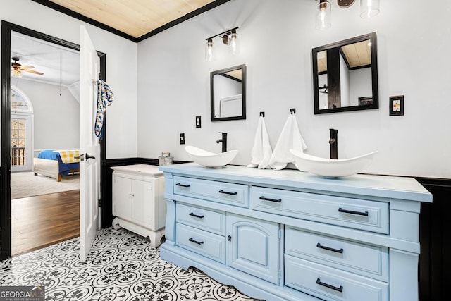 full bath featuring crown molding, lofted ceiling, a sink, and connected bathroom