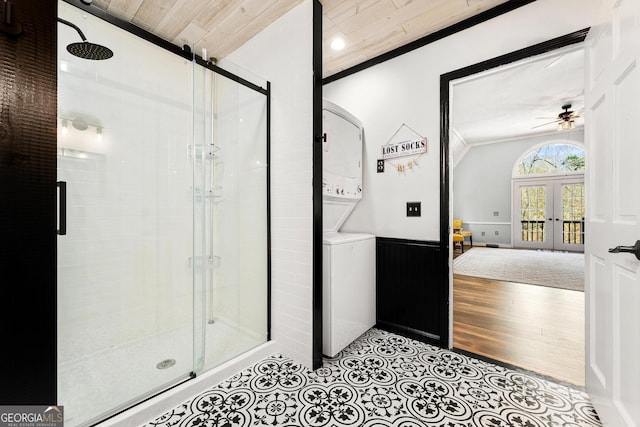 full bath with stacked washer and dryer, a wainscoted wall, crown molding, french doors, and a shower stall