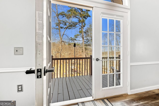 doorway featuring baseboards and wood finished floors