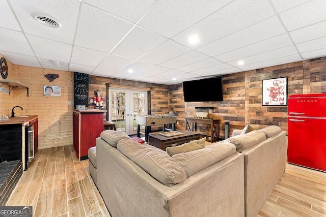 living room featuring beverage cooler, french doors, light wood-style flooring, and visible vents