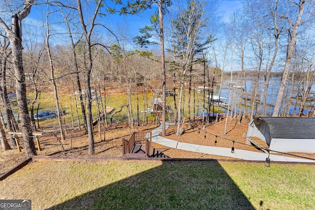 view of yard featuring a water view and an outdoor structure