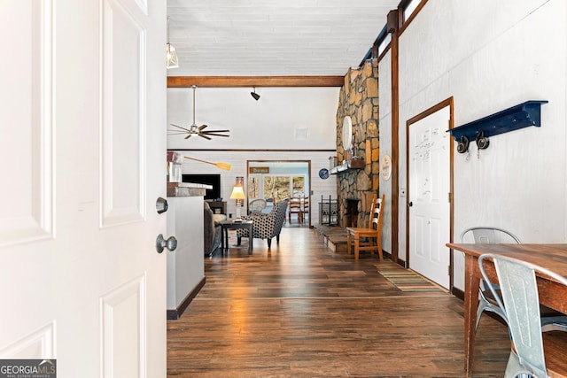 entryway featuring ceiling fan, beamed ceiling, a fireplace, and wood finished floors