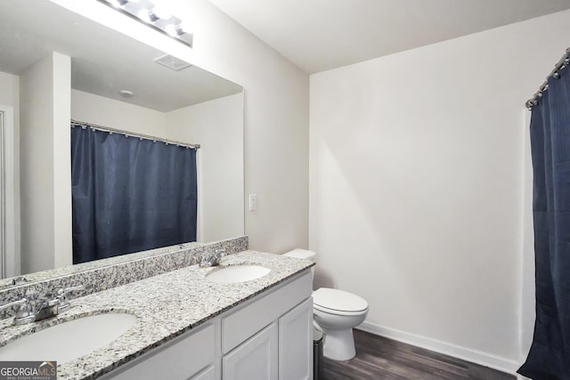 bathroom with visible vents, a sink, toilet, and wood finished floors