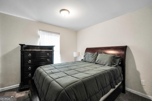 bedroom featuring dark colored carpet and baseboards