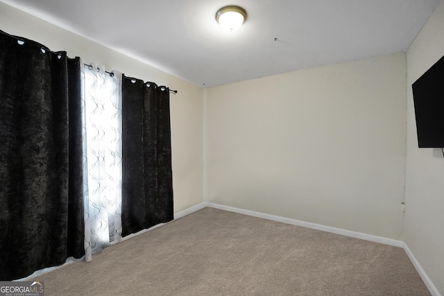 carpeted empty room with baseboards