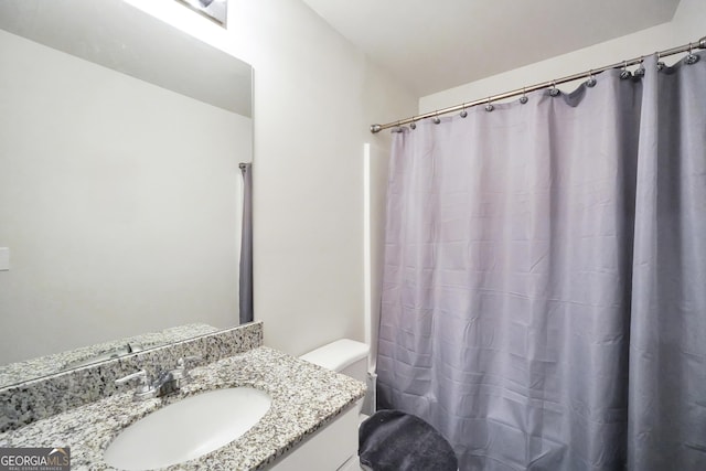 bathroom featuring a shower with curtain, vanity, and toilet