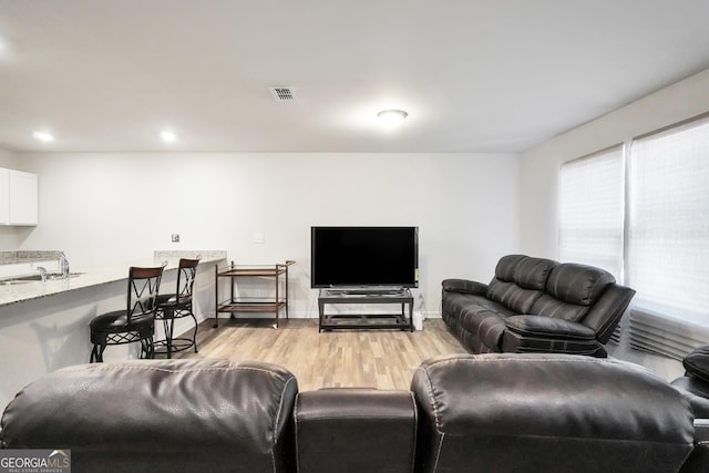 living room with light wood-style flooring, recessed lighting, visible vents, and baseboards