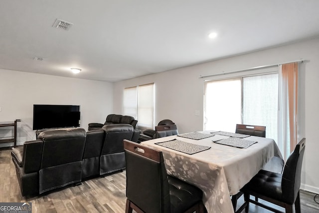 dining area with light wood-style floors and visible vents