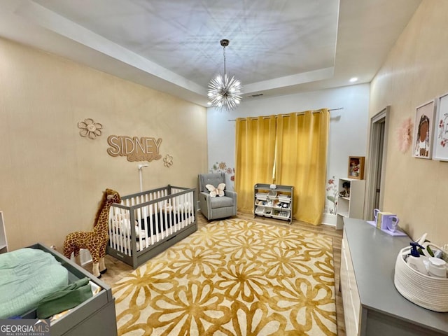 bedroom featuring a raised ceiling, visible vents, and an inviting chandelier