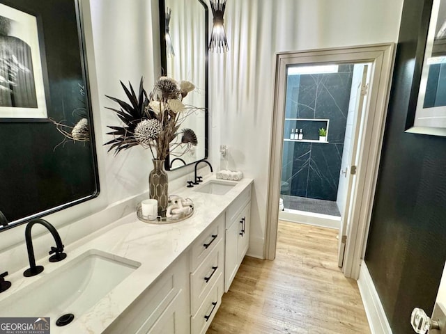 full bathroom with wood finished floors, a sink, toilet, and a shower stall