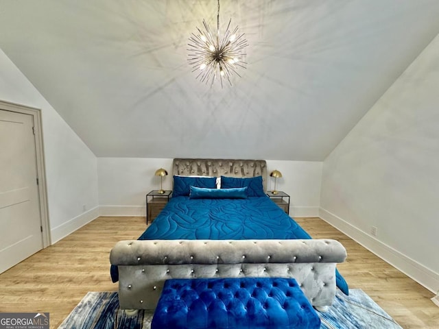 bedroom with an inviting chandelier, baseboards, and wood finished floors