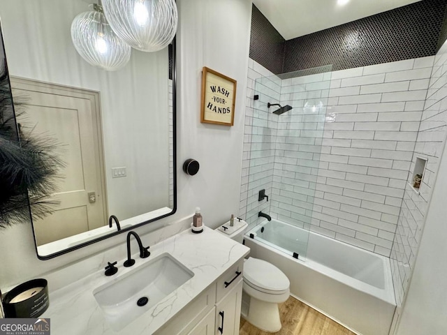 bathroom featuring toilet, bathtub / shower combination, wood finished floors, and vanity