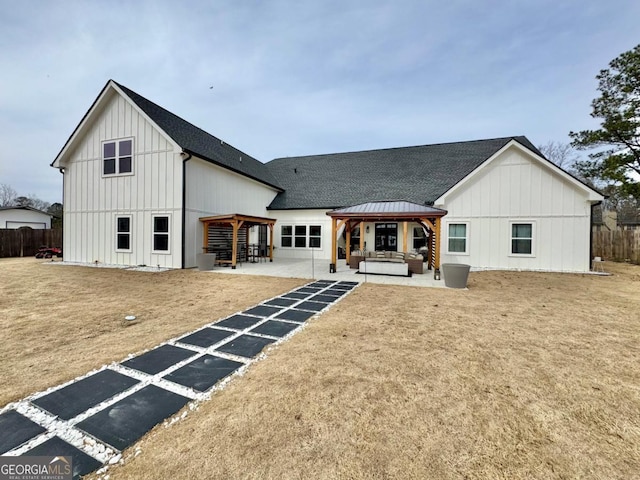 rear view of property with a shingled roof, a gazebo, board and batten siding, a patio area, and fence