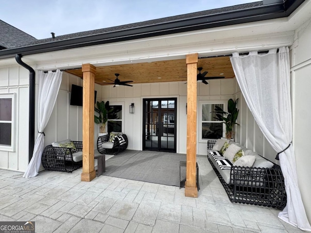 property entrance with board and batten siding, a patio, a ceiling fan, and french doors