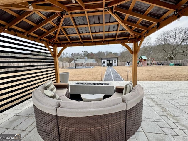 view of patio featuring an outdoor fire pit, fence, playground community, and a gazebo