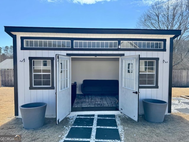 view of outbuilding with fence and an outdoor structure