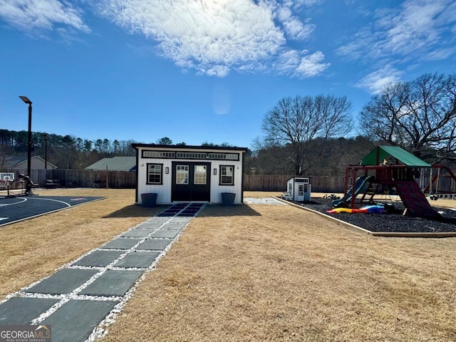 view of playground with a yard, an outdoor structure, and a fenced backyard