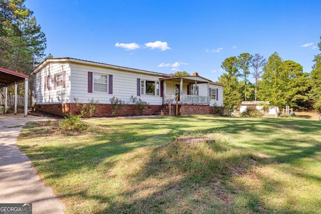 ranch-style house featuring a front yard, covered porch, crawl space, and a detached carport