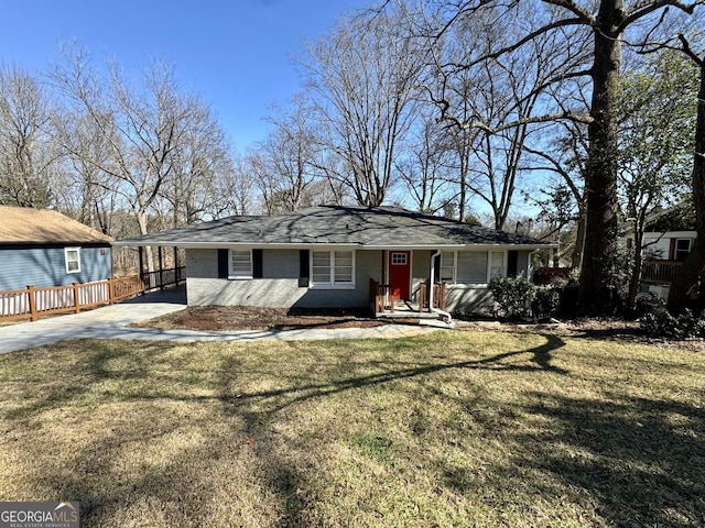 rear view of house with a yard, concrete driveway, and brick siding