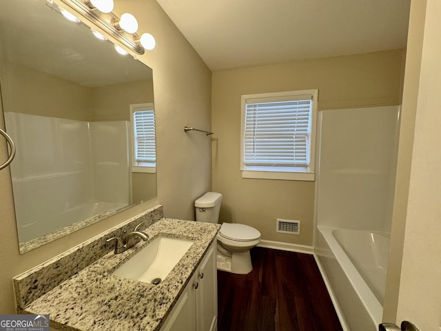 bathroom with baseboards, visible vents, toilet, wood finished floors, and vanity