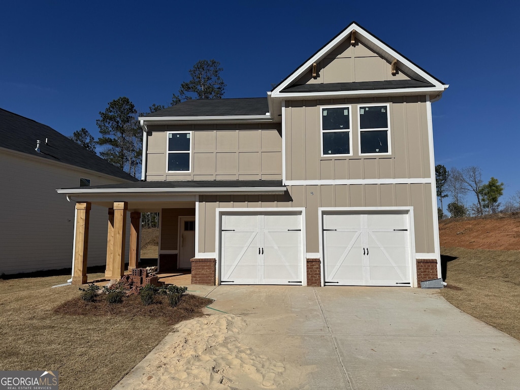 view of front of house with brick siding, roof with shingles, concrete driveway, an attached garage, and board and batten siding