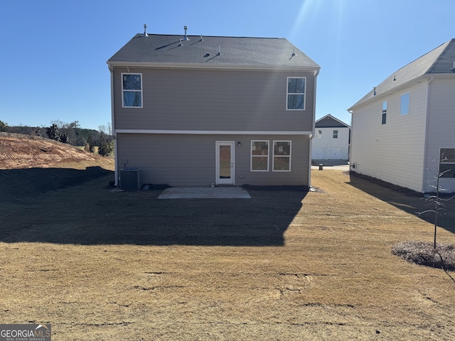 back of property featuring central AC unit, a lawn, and a patio