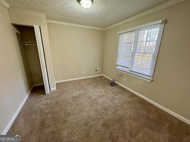 unfurnished bedroom featuring baseboards, carpet, visible vents, and crown molding