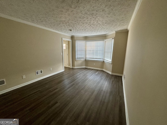 unfurnished room with dark wood-type flooring, visible vents, crown molding, and baseboards