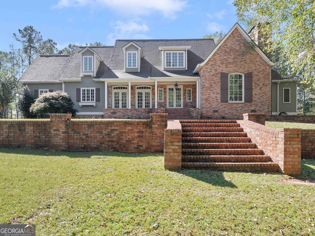 view of front facade featuring a front yard, french doors, and brick siding